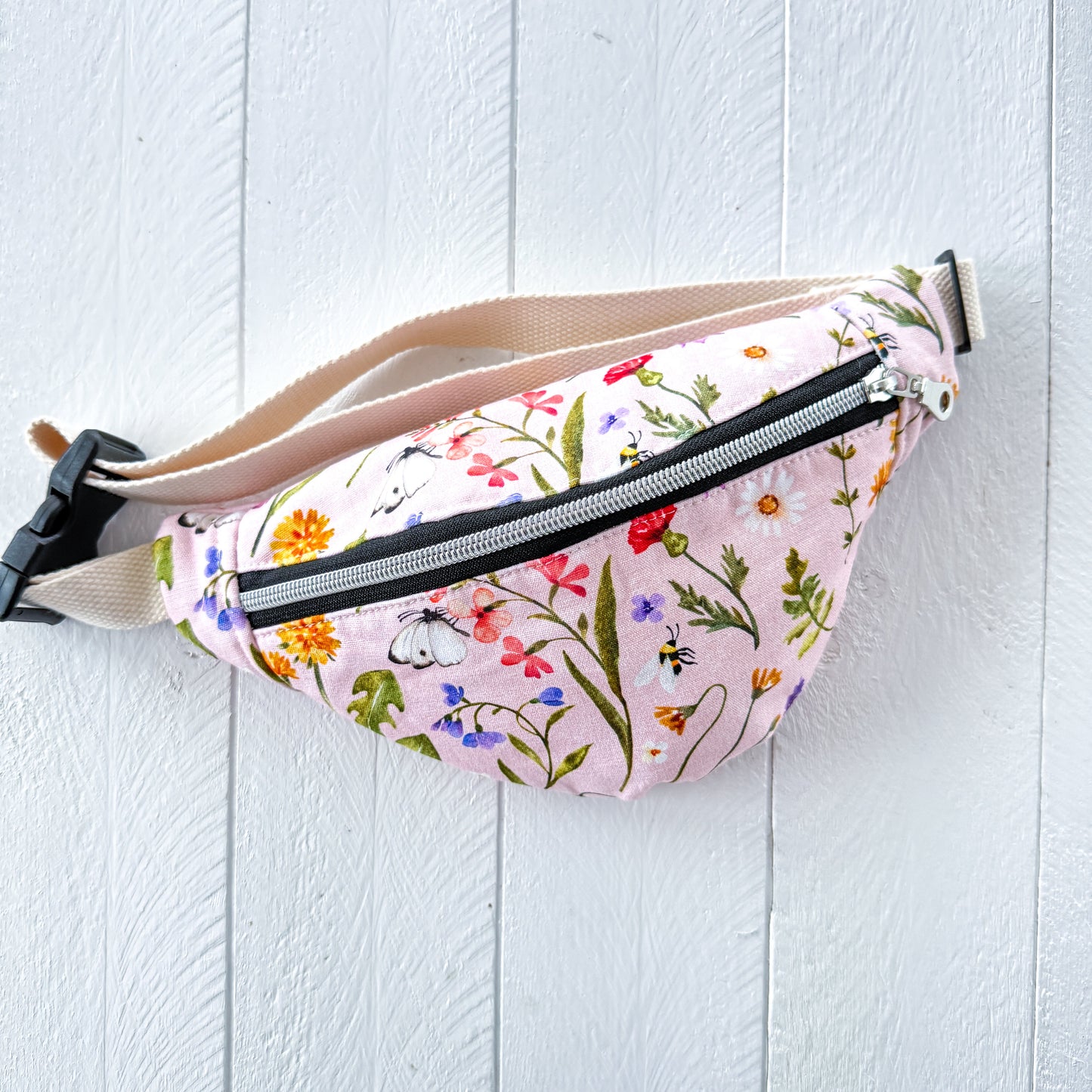 Floral-patterned fanny pack on a light wooden surface