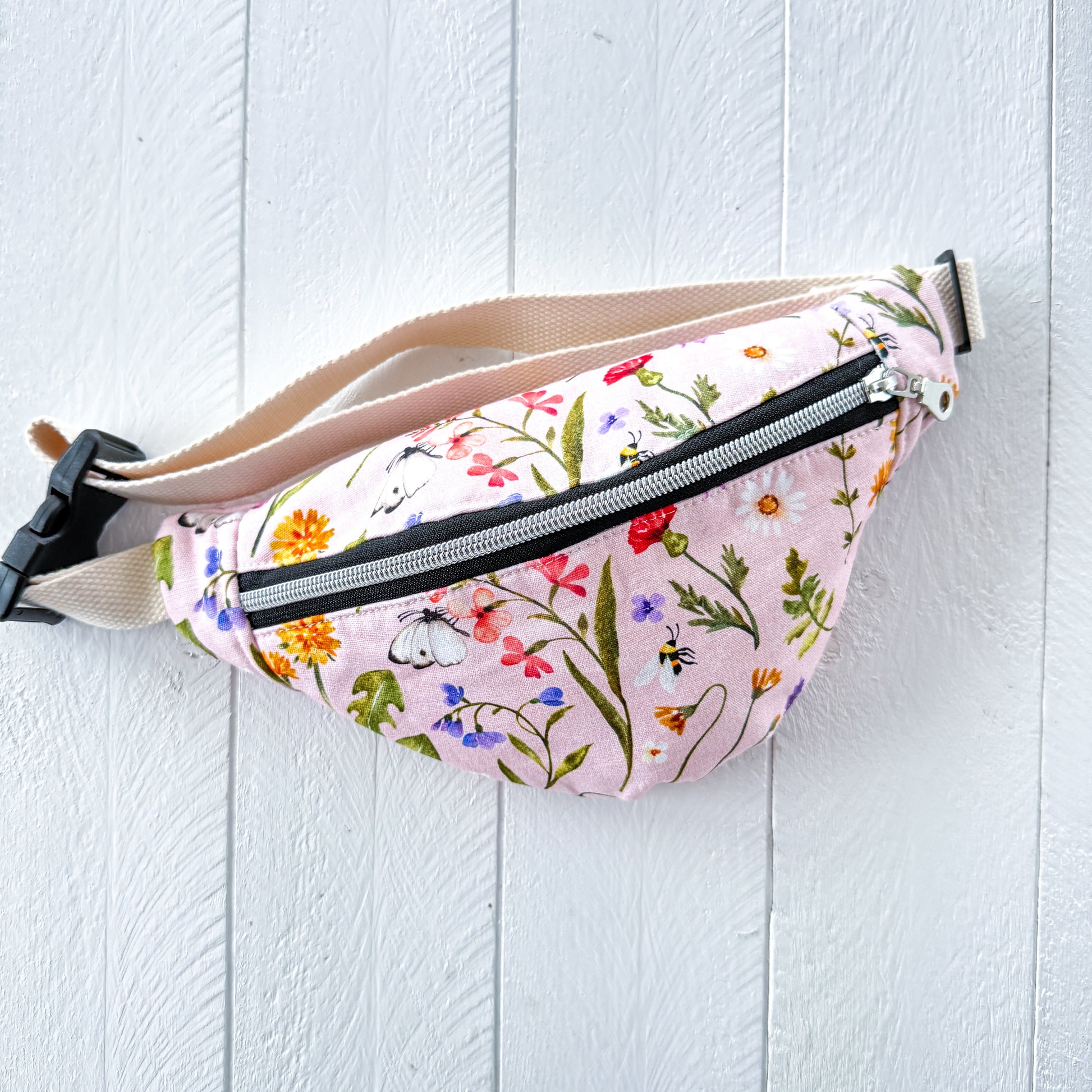 Floral-patterned fanny pack on a light wooden surface