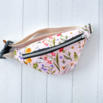 Floral-patterned fanny pack on a light wooden surface