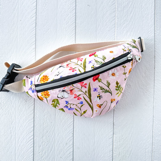 Floral-patterned fanny pack on a light wooden surface
